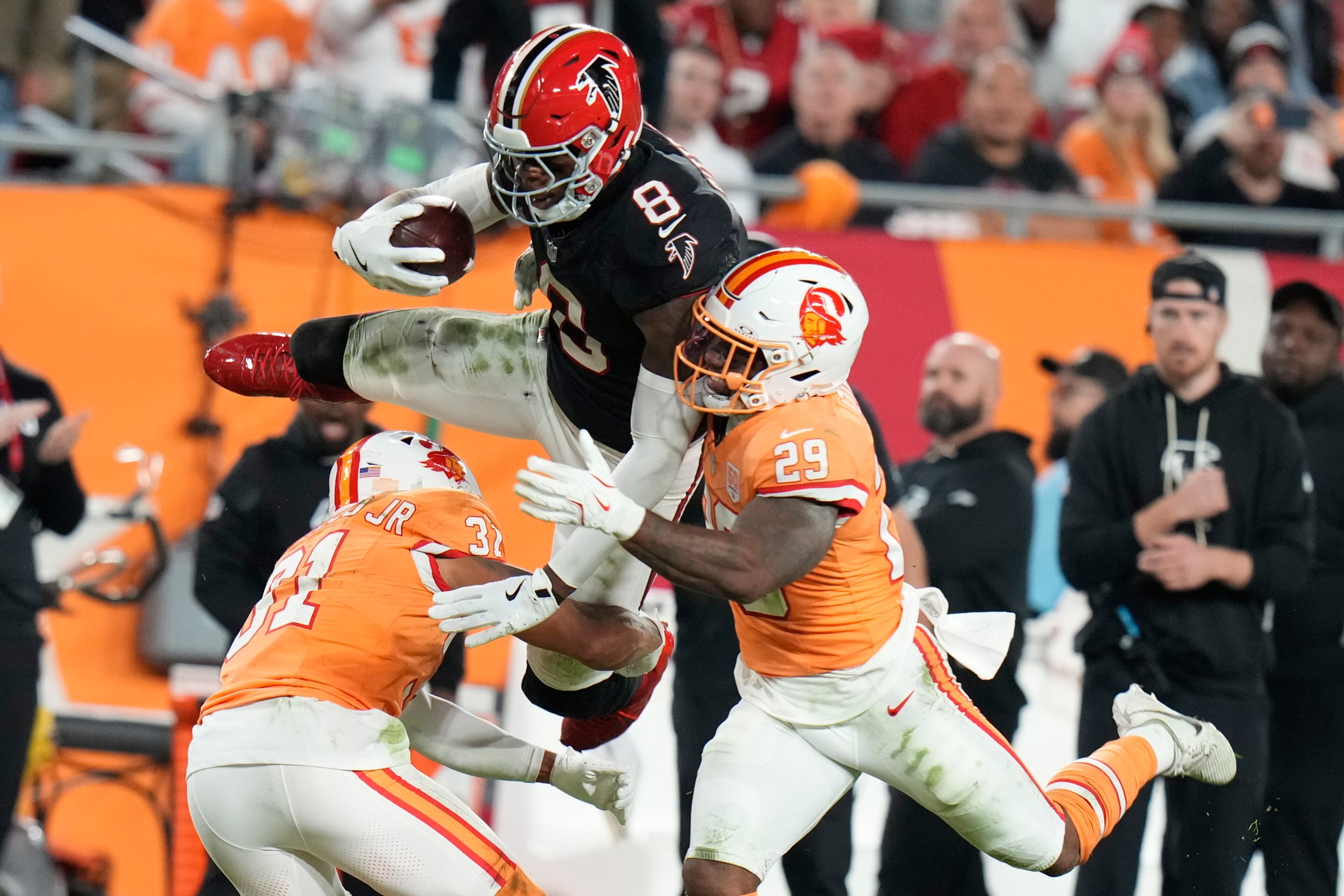 Atlanta Falcons tight end Kyle Pitts Sr. (8) leaps over Tampa Bay Buccaneers safety Christian Izien (29) during the first half of an NFL football game, Thursday, Dec. 11, 2025, in Tampa, Fla. (AP Photo/Chris O'Meara)