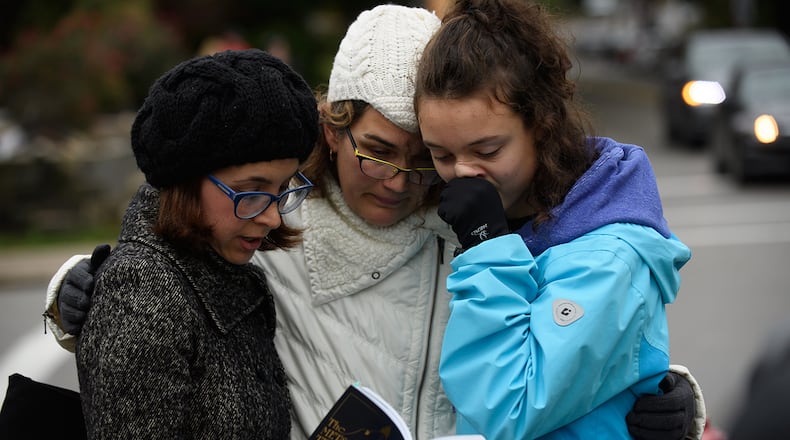 PITTSBURGH, PA - OCTOBER 27: Tammy Hepps, Kate Rothstein and her daughter, Simone Rothstein, 16, pray from a prayerbook a block away from the site of a mass shooting at the Tree of Life Synagogue in the Squirrel Hill neighborhood . (Photo by Jeff Swensen/Getty Images)