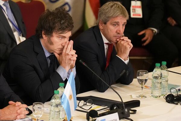 FILE - Argentina's President Javier Milei, left, and Economy Minister Luis Caputo attend the Mercosur Summit in Montevideo, Uruguay, Dec. 6, 2024. (AP Photo/Matilde Campodonico, File)