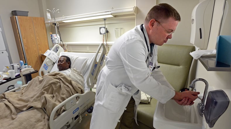 Nurse Practitioner John Bernhard washes his hands after he checked a patient at WellStar Cobb Hospital in Austell.