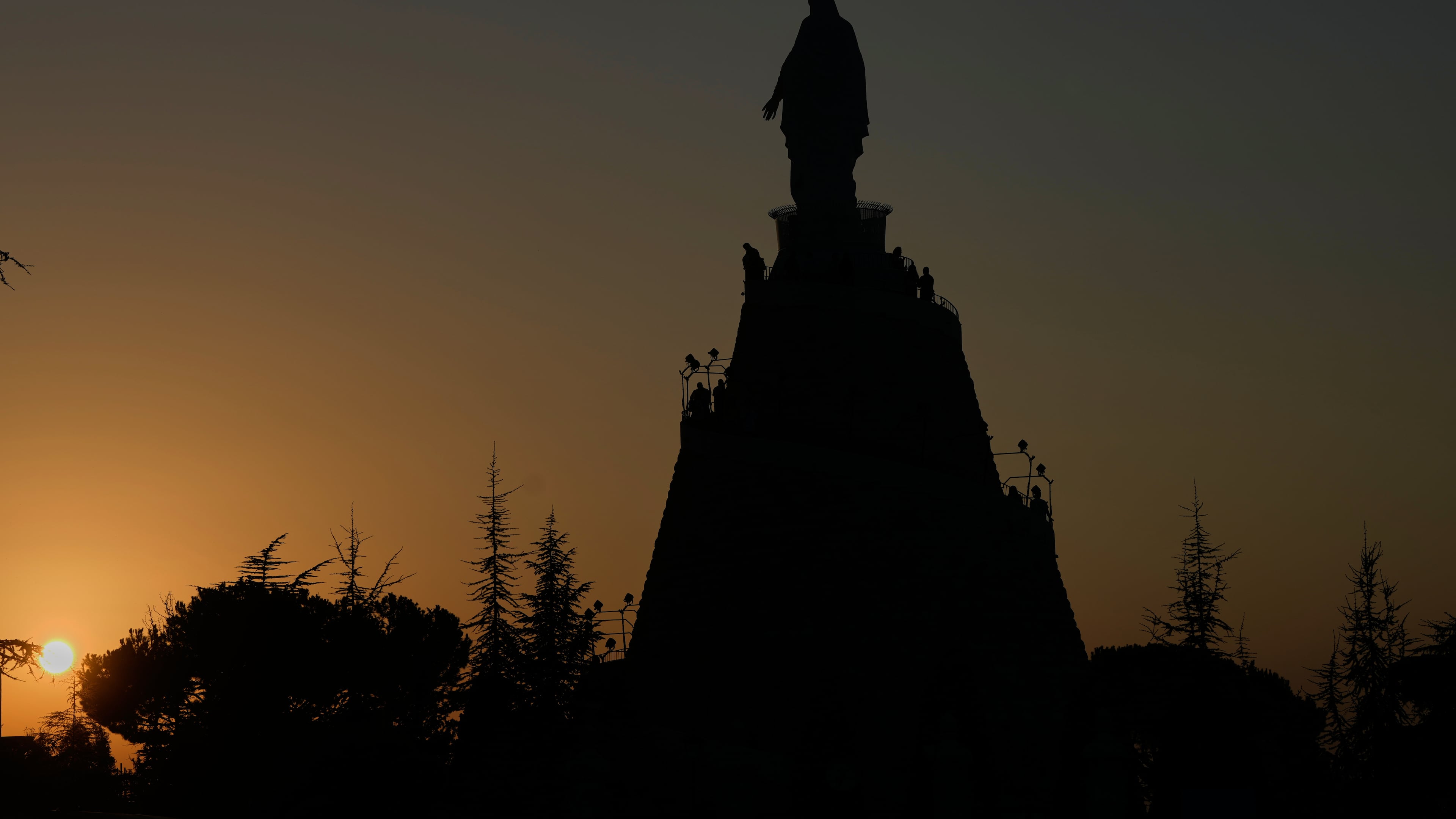 Worshippers visit Our Lady of Lebanon shrine in Harissa, north of Beirut, Lebanon, Sunday, Nov. 9, 2025, as the sun sets over the Mediterranean Sea. (AP Photo/Hassan Ammar)