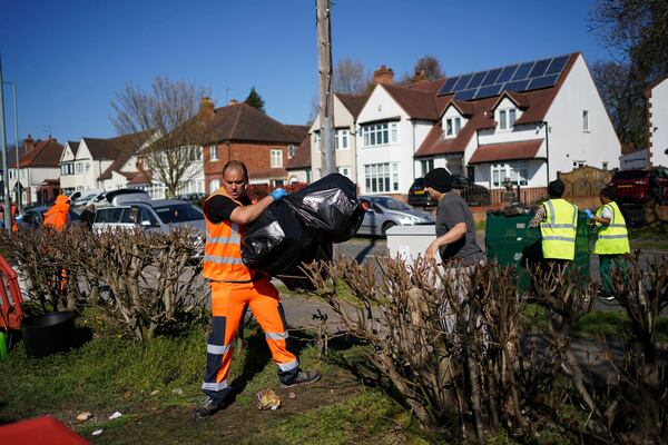 Local residents deliver rubbish to mobile collection vehicles in Erdington, Birmingham, England, Monday, April 7, 2025. (Jacob King/PA via AP)