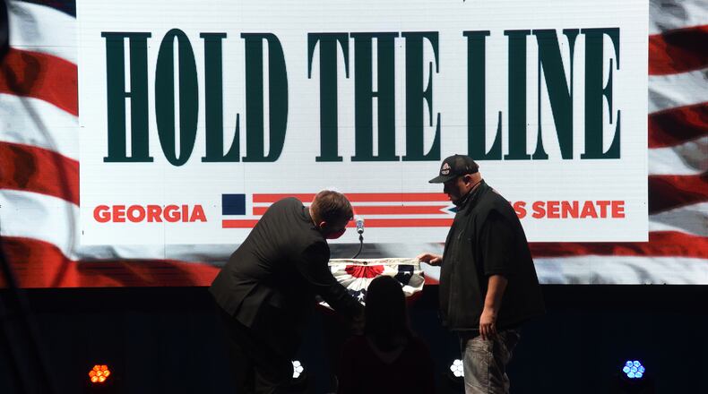 Staffers decorate the podium before an Election Night party for U.S. Sens. David Perdue and Kelly Loeffler at the Grand Hyatt Hotel in Buckhead on Tuesday, January 5, 2021. (Hyosub Shin / Hyosub.Shin@ajc.com)
