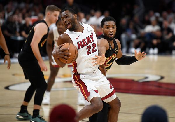Miami Heat forward Andrew Wiggins (22) spins past Cleveland Cavaliers guard Donovan Mitchell during the first half in Game 3 of an NBA basketball first-round playoff series, Saturday, April 26, 2025, in Miami. (AP Photo/Michael Laughlin)
