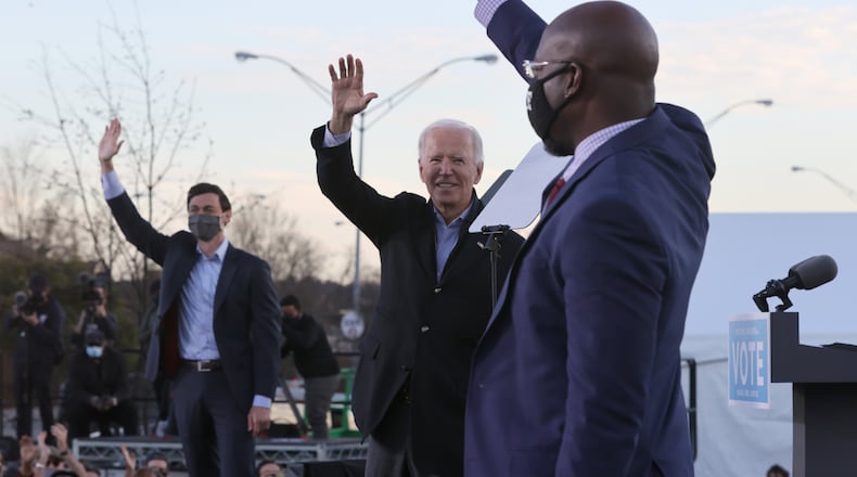 President-elect Joe Biden, middle, along with Democratic candidates for the U.S. Senate Jon Ossoff, left, and Rev. Raphael Warnock, greet supporters during a campaign rally in the parking lot of Centerparc Stadium on January 4, 2021, in Atlanta. (Chip Somodevilla/Getty Images/TNS)