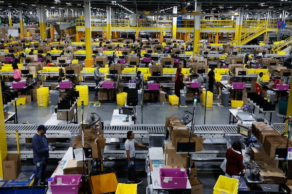 Amazon employees work at the Single Pack Station in Stone Mountain, where packages are prepared for delivery. The world’s largest e-commerce company is seeking taxpayer-backed assistance to transform a southwest Atlanta warehouse into a gigantic package facility. (Miguel Martinez/AJC 2024)
