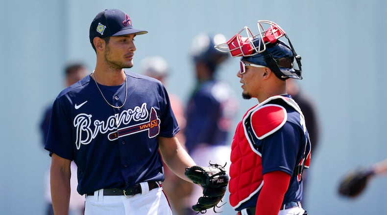 Atlanta Braves pitcher, Freddy Tarnok, left, talks with catcher William Contreras after warm ups during spring training at the CoolToday Park Monday March 14, 2022, in North Port, Fla. (AP Photo/Steve Helber)