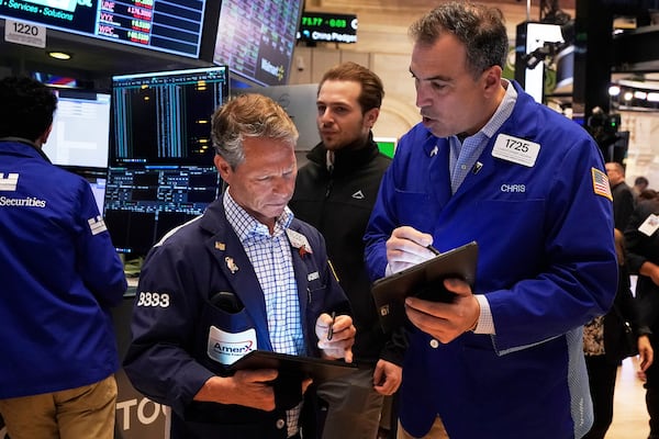 Traders Robert Charmak, left center, and Christopher Lagana, right, work on the floor of the New York Stock Exchange, Friday, April 25, 2025. (AP Photo/Richard Drew)