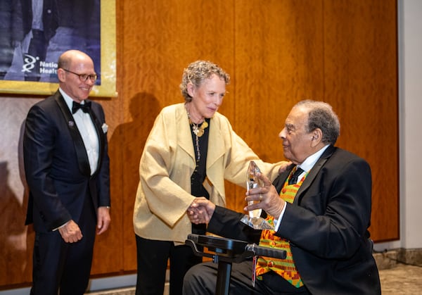 The Hagedorn siblings, Paul (left) and Susan, give the humanitarian award to Andrew Young during Monday's gala. Each told stories about how National Jewish Health saved their lives as children. (Jenni Girtman, Amanda Brown Olmstead PR for the AJC)
