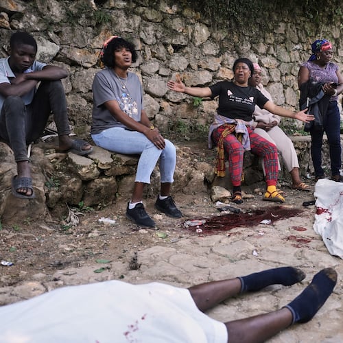 People gather next to the bodies of people they said were their relatives and were killed in a gang attack in the Kenscoff neighborhood of Port-au-Prince, Haiti, Monday, Aug. 24, 2026. (AP Photo/Odelyn Joseph)