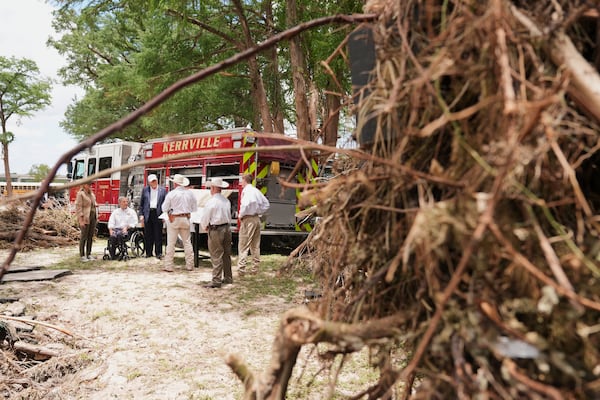 First lady Melania Trump, from left, Texas Gov. Greg Abbott and President Donald Trump are briefed on flood damage in Kerrville, Texas, Friday, July 11, 2025. (AP Photo/Jacquelyn Martin)