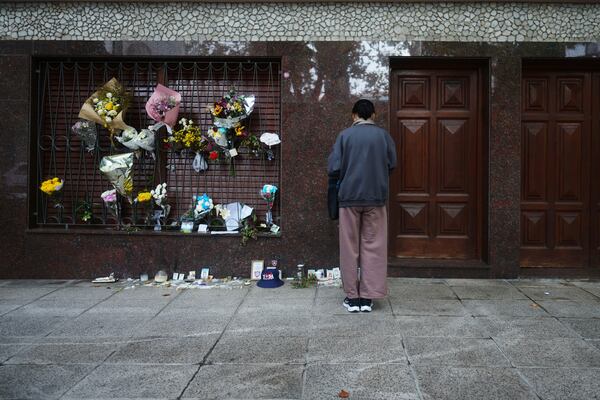 Flowers cover the exterior of the childhood home of Jorge Bergoglio, who later became Pope Francis, in Flores neighborhood where he grew up in Buenos Aires, Argentina, Thursday, April 24, 2025. (AP Photo/Natacha Pisarenko)