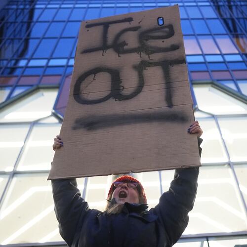 A demonstrator holds a sign reading "ICE OUT" during a protest outside the office of Sen. Amy Klobuchar, D-Minn., on Monday, Jan. 26, 2026, in Minneapolis. (AP Photo/Adam Gray)