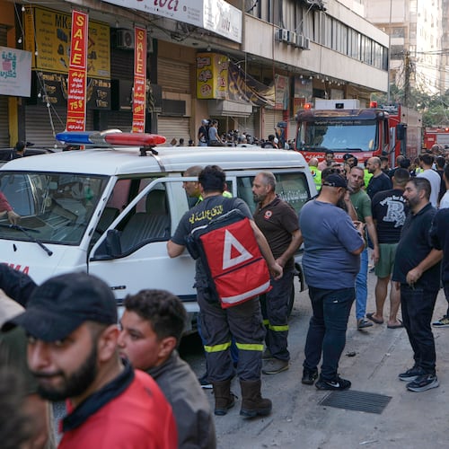 People and Civil Defence workers gather at the site where an Israeli airstrike hit an apartment building on Dahiyeh in the southern suburb of Beirut, Sunday Nov. 23, 2025. (AP Photo/Bilal Hussein)