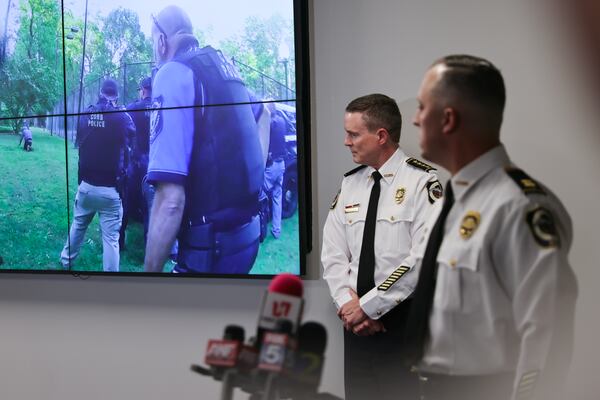 (Left to right) Cobb County Police Chief Stuart VanHoozer and Captain Darin Hull watch video of the arrest of the Midtown shooter during a news conference at Cobb County Police Headquarters on May 16, 2023. (Natrice Miller/natrice.miller@ajc.com)