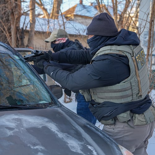 Activists are approached by a federal agent brandishing a firearm, for following agent vehicles, on Tuesday, Feb. 3, 2026, in Minneapolis. (AP Photo/Ryan Murphy)