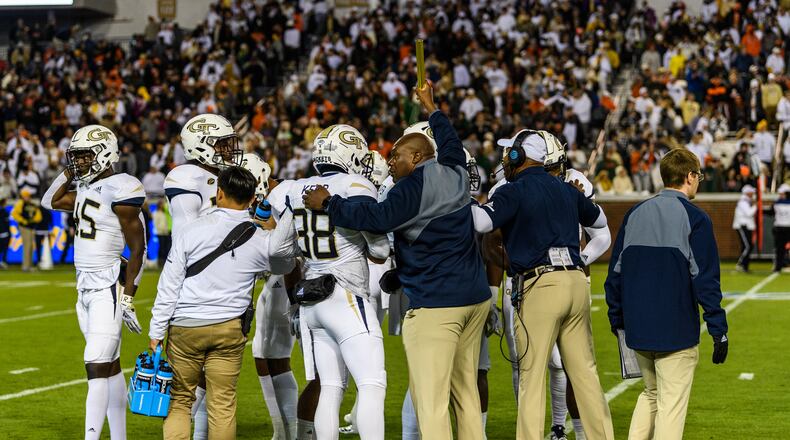 Georgia Tech character development coach Derrick Moore (holding baton) huddles with a special-teams unit before it goes onto the field in the team's 27-21 win over Miami November 10, 2018. (Danny Karnik/Georgia Tech Athletics)