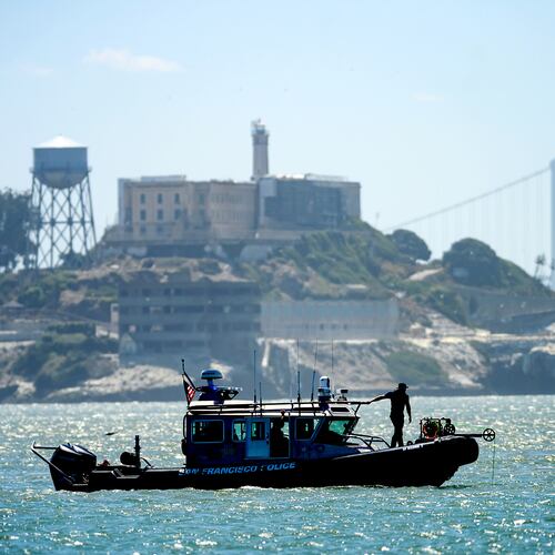 A police boat passes Alcatraz Island as search and rescue operations continue for victims of a Tuesday boat sinking on Wednesday, July 15, 2026, in San Francisco. (AP Photo/Noah Berger)