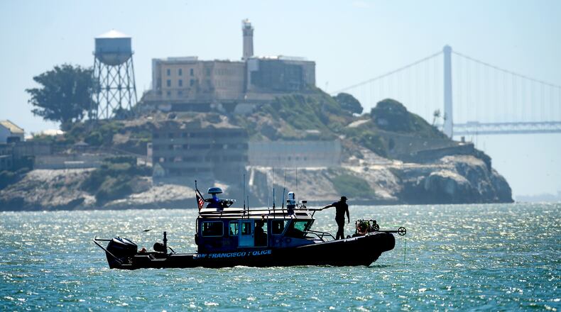 A police boat passes Alcatraz Island as search and rescue operations continue for victims of a Tuesday boat sinking on Wednesday, July 15, 2026, in San Francisco. (AP Photo/Noah Berger)