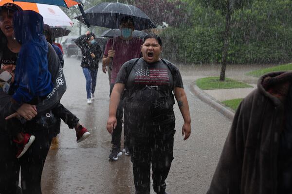 Joni Minter marches through the rain alongside others hoping to to spread awareness of the death of Marvin Scott III outside the Byron Nelson PGA golf tournament at TPC Craig Ranch in McKinney, Texas. (Shelby Tauber/The Dallas Morning News/TNS)
