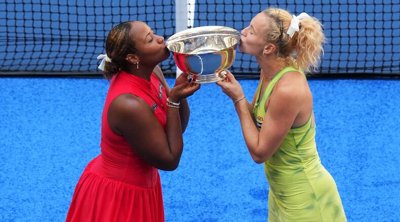 Taylor Townsend, of the United States, left, and Katerina Siniakova, of the Czech Republic, right, kiss their trophy after winning the women's doubles final of the U.S. Open tennis championships against Ashlyn Krueger, of the United States, and Robin Montgomery, of the United States, Friday, Sept. 11, 2026, in New York. (AP Photo/Kirsty Wigglesworth)