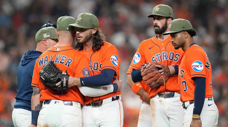Houston Astros starting pitcher Spencer Arrighetti, center left, hugs Christian Walker after a single by Texas Rangers' Justin Foscue broke up his no-hit bid during the eighth inning of a baseball game, Friday, May 15, 2026, in Houston. (AP Photo/Karen Warren)
