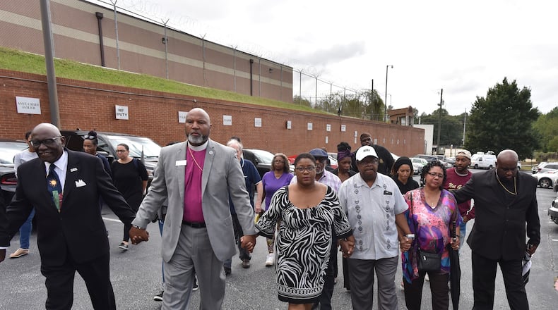 Tamara Cotman, center,  holds hands with supporters as she walks to the Fulton County Jail Tuesday. Cotman, convicted in the Atlanta Public Schools cheating scandal, will begin serving her prison sentence after her appeals ran out.
