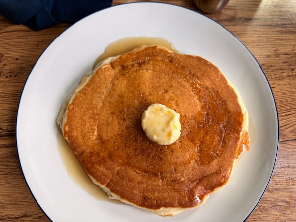 Overhead view of a pancake with a pat of butter in the center.