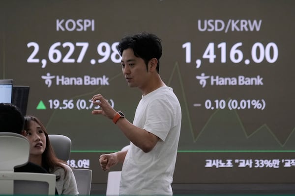 Currency traders work near a screen showing the Korea Composite Stock Price Index (KOSPI), left, and the foreign exchange rate between U.S. dollar and South Korean won at the foreign exchange dealing room of the KEB Hana Bank headquarters in Seoul, South Korea, Wednesday, May 14, 2025. (AP Photo/Ahn Young-joon)