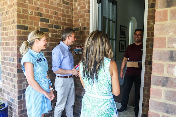 DNC Chair Ken Martin and Senate District 21 Candidate Debra Shigley speak with a voter as they campaign in Milton, Ga, on Saturday, September 20, 2025. (Abbey Cutrer / AJC)