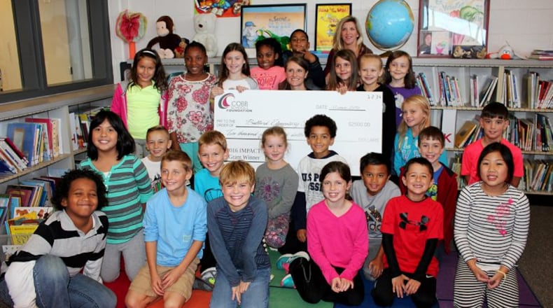Almost $31,000 for 19 grants have been awarded to Cobb public school teachers by the Atlanta Braves Foundation and the Cobb Schools Foundation. Bullard Elementary third grade teacher Ginny Coalson poses with her students after the Cobb Schools Foundation awarded her a $2,500 IMPACT grant along with second grade teacher Shery Dishman. Courtesy of Cobb County School District