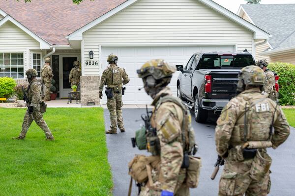 Armed FBI agents search for an active shooter, sweeping a neighborhood adjacent to the home of Minnesota DFL State Representative Melissa Hortman, in Brooklyn Park, Minn., Saturday, June 14, 2025. (Alex Kormann/Star Tribune via AP)