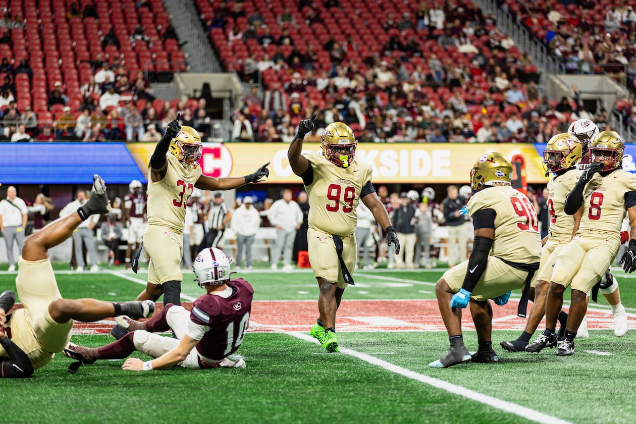 Creekside's Daniel Holt (right center, with blue gloves) celebrates with teammates Tavarre Terrell (left center, with two arms raised) and Cassius Burch (center, with one arm raised) during the GHSA Class 4A state championship game vs. Benedictine in December. The Seminoles won 42-39. (Courtesy of Cassius Burch and IQue Media Group)