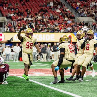 Creekside's Daniel Holt (right center, with blue gloves) celebrates with teammates Tavarre Terrell (left center, with two arms raised) and Cassius Burch (center, with one arm raised) during the GHSA Class 4A state championship game vs. Benedictine in December. The Seminoles won 42-39. (Courtesy of Cassius Burch and IQue Media Group)