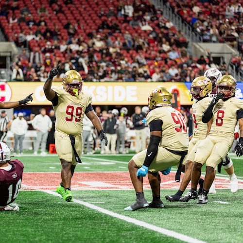 Creekside's Daniel Holt (right center, with blue gloves) celebrates with teammates Tavarre Terrell (left center, with two arms raised) and Cassius Burch (center, with one arm raised) during the GHSA Class 4A state championship game vs. Benedictine in December. The Seminoles won 42-39. (Courtesy of Cassius Burch and IQue Media Group)