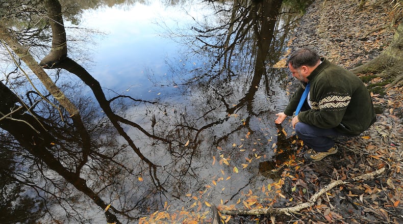 Valdosta State University Professor Don Thieme checks the water color and clarity in a sinkhole near the site of a proposed Sabal Trail pipeline. Curtis Compton / ccompton@ajc.com