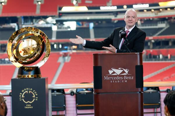 FIFA President Gianni Infantino gestures toward the Club World Cup trophy during an April news conference at Mercedes-Benz Stadium.