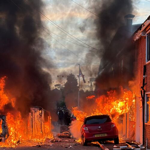 Vehicles set on fire by protesters burn on Lendrick Street in east Belfast, Northern Ireland, on Tuesday, June 9, 2026, after the arrest of a Sudanese man accused of stabbing a man in the northern part of the city. (PA via AP)