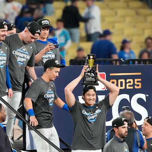 Los Angeles Dodgers' Shohei Ohtani celebrates the the trophy after their win against the Milwaukee Brewers in baseball's National League Championship Series, Friday, Oct. 17, 2025, in Los Angeles. (AP Photo/Mark J. Terrill)