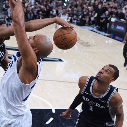 Minnesota Timberwolves center Rudy Gobert, center, is blocked by San Antonio Spurs forward Keldon Johnson (3) as forward Victor Wembanyama (1) looks on during the second half of Game 5 of an NBA basketball second-round playoffs series in Minneapolis, Tuesday, May 12, 2026. (AP Photo/Eric Gay)