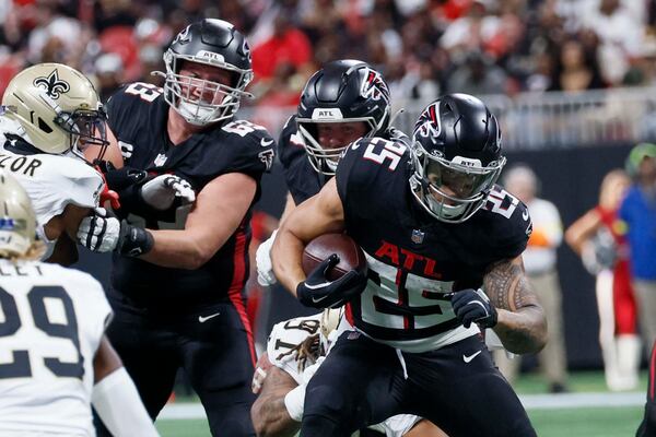 Falcons running back Tyler Allgeier (right) —pictured breaking a tackle against the Saints on Sunday, Jan. 4, 2026 — rushed for more than 1,000 yards as a rookie and has served as Bijan Robinson’s backup for the past three seasons. (Miguel Martinez/AJC)