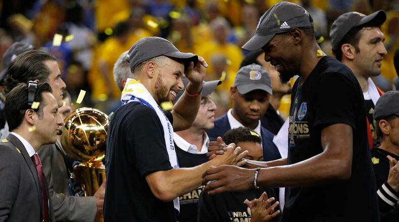 Stephen Curry and Kevin Durant celebrate after Golden State won the NBA championship in June.