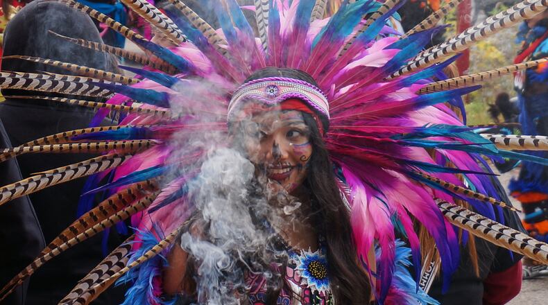 A member of an Aztec dance group holds incense during a commemoration of Día de Muertos (Day of the Dead) at El Colegio High School in Minneapolis on Saturday, Nov. 1, 2025. (AP Photo/Giovanna Dell'Orto)