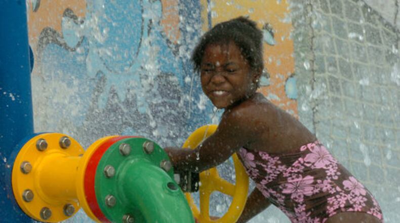 Fransine Myoike, 7, is sprayed by water as she plays with a mock fire hydrant. At long last, DeKalb County has cut the ribbon on its first major water park, the Browns Mill Aquatic Center in Lithonia. The center comprises three water features on its nearly 35,000 square foot grounds: a tot pool, a "lazy river" and a leisure pool. There is a food concession, bathrooms, showers, picnic tables and inner tubes for floating.