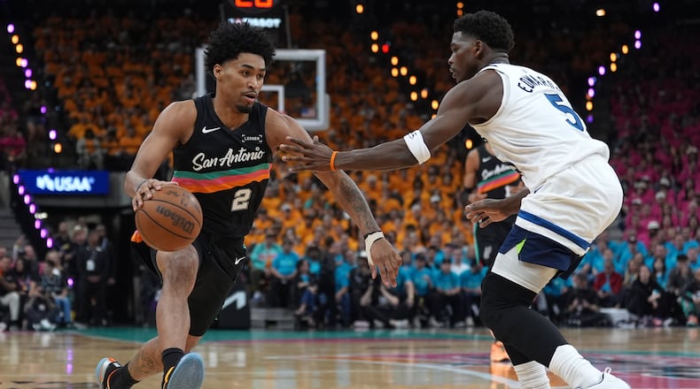 San Antonio Spurs guard Dylan Harper (2) works toward the basket as Minnesota Timberwolves guard Anthony Edwards (5) defends during the first half in Game 1 of a second-round NBA playoffs basketball series in San Antonio, Monday, May 4, 2026. (AP Photo/Eric Gay)