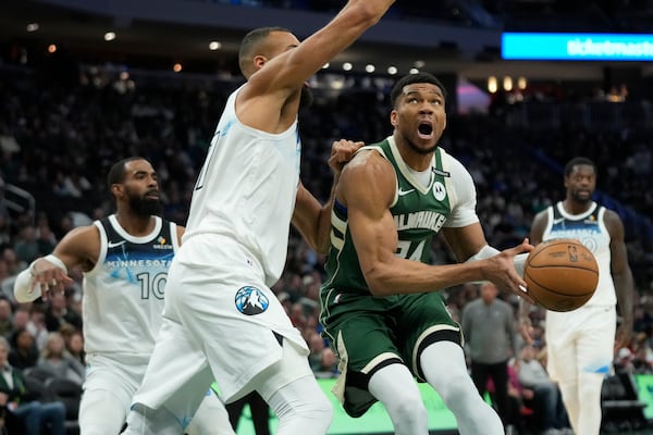 Milwaukee Bucks' Giannis Antetokounmpo drives to the basket against Minnesota Timberwolves' Rudy Gobert during the first half of an NBA basketball game Tuesday, April 8, 2025, in Milwaukee. (AP Photo/Aaron Gash)