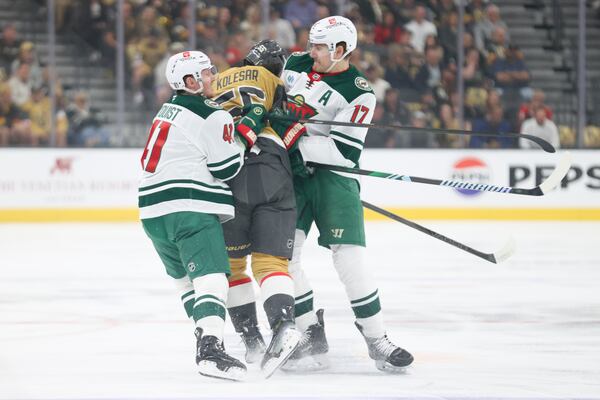 Minnesota Wild center Gustav Nyquist (41) and left wing Marcus Foligno (17) check Vegas Golden Knights right wing Keegan Kolesar (55) during the first period in Game 1 of an NHL hockey Stanley Cup first-round playoff series Sunday, April 20, 2025, in Las Vegas. (AP Photo/Ian Maule)