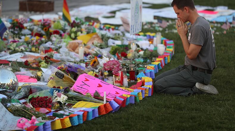 ORLANDO, FL - JUNE 14: Matt Mitchell pays his respects at a memorial in front the Dr. Phillips Center for the Performing Arts to the victims of the Pulse gay nightclub shooting where Omar Mateen allegedly killed 49 people on June 14, 2016 in Orlando, Florida. The mass shooting killed at least 49 people and injuring 53 others in what is the deadliest mass shooting in the country's history. (Photo by Joe Raedle/Getty Images)