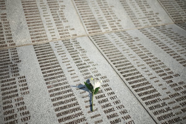 A flower is seen on a monument with the names of those killed in Srebrenica genocide, at the Memorial Center in Potocari, Bosnia, Friday, July 11, 2025. (AP Photo/Armin Durgut)