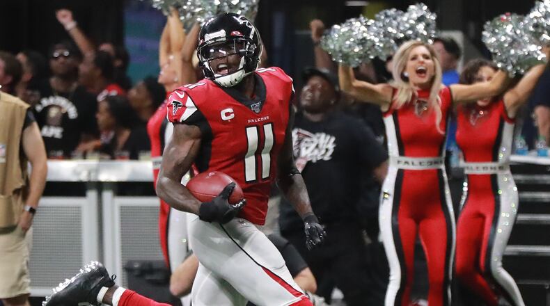 Falcons wide receiver Julio Jones looks over his shoulder on his way to the end zone for the game-winning touchdown.  Curtis Compton/ccompton@ajc.com